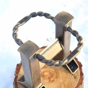 Peut inclure: Un support en m&eacute;tal artisanal avec un anneau en m&eacute;tal torsad&eacute; et des poteaux carr&eacute;s. Le support est mont&eacute; sur une base en bois. Le texte "Minisize-model" est visible.