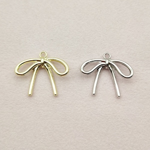 May include: Two gold and silver bow charms with a loop at the top for attaching to jewelry or other crafts.