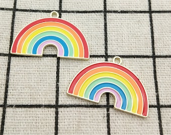 May include: Two gold-colored rainbow charms with a loop for hanging. The charms are enamel painted with red, orange, yellow, green, blue, indigo, and violet.