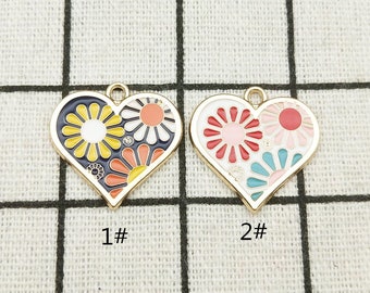 May include: Two gold heart-shaped charms with enamel floral designs. The charm on the left has a blue, yellow, and orange floral design. The charm on the right has a pink, red, and blue floral design. The charms are labeled 1# and 2#.