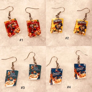 May include: A set of ten cereal box earrings. The earrings are made of metal and feature miniature replicas of popular cereal boxes, including Froot Loops, Crunch Berries, Rice Krispies, and Frosted Flakes. The earrings are a fun and whimsical way to show your love for breakfast cereal.