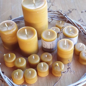 Pu&ograve; includere: Una collezione di 12 candele di cera d'api in varie dimensioni e forme. Le candele sono disposte in cerchio su una superficie di legno. Le candele sono tutte naturali e hanno un colore caldo e miele.
