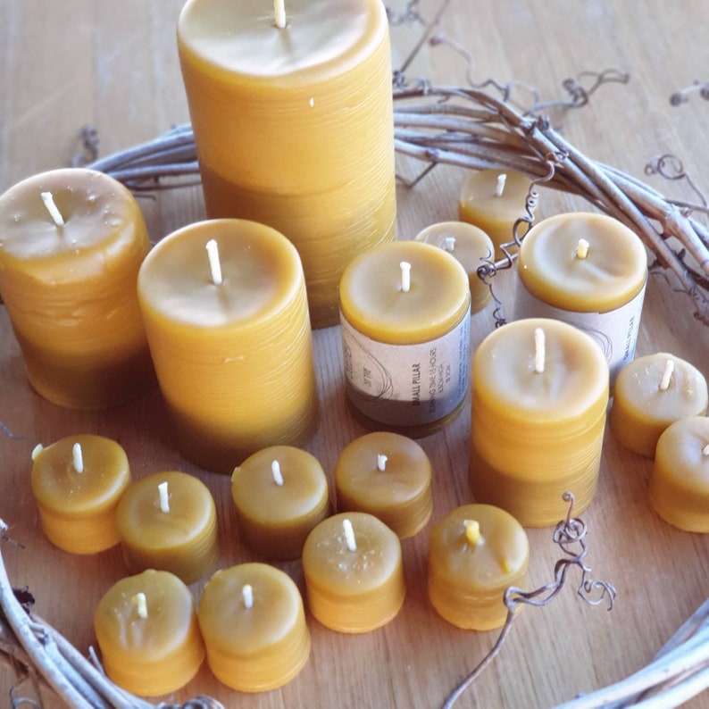 Pu&ograve; includere: Una collezione di 12 candele di cera d'api in varie dimensioni e forme. Le candele sono disposte in cerchio su una superficie di legno. Le candele sono tutte naturali e hanno un colore caldo e miele.