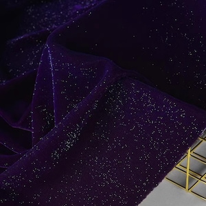 May include: Purple velvet fabric with silver glitter. The fabric has a soft, luxurious feel and is perfect for adding a touch of sparkle to any project.