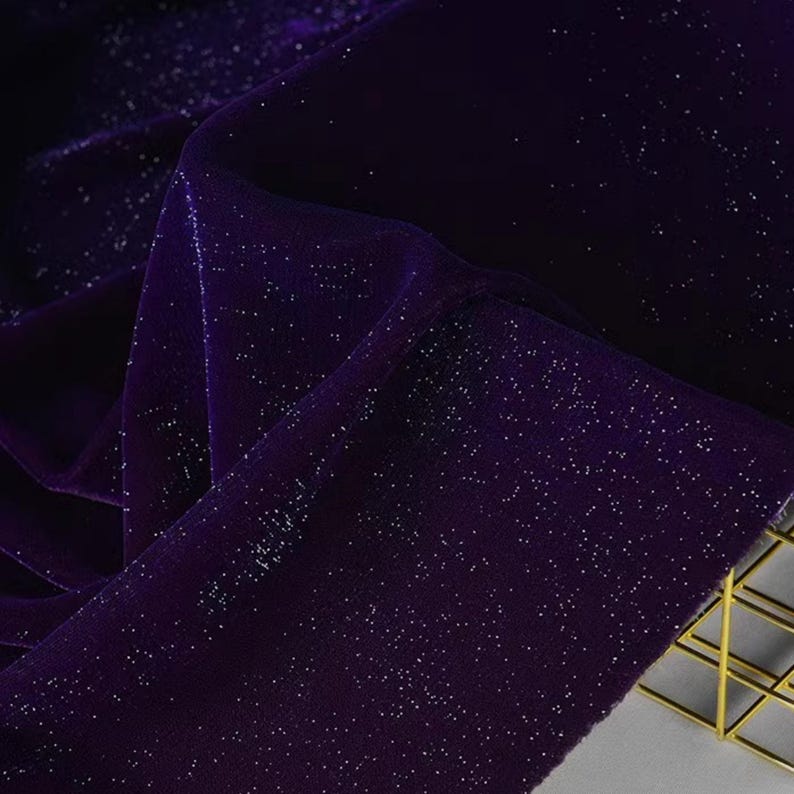 May include: Purple velvet fabric with silver glitter. The fabric has a soft, luxurious feel and is perfect for adding a touch of sparkle to any project.