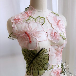 May include: Pink and green floral embroidery applique with a delicate sheer fabric. The design features hibiscus flowers and tropical leaves.