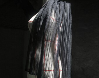 May include: A black sheer pleated scarf draped over a dress form. The scarf is made of a lightweight, flowing fabric and has a delicate, feminine look.