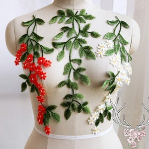 Puede incluir: Una aplicación floral con flores rojas y blancas y hojas verdes. La aplicación está sobre un fondo blanco y es perfecta para añadir un toque de elegancia a cualquier proyecto.