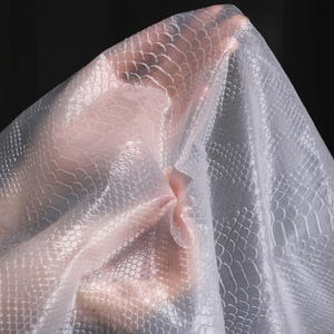 May include: A clear plastic sheet with a textured, snake-skin pattern.