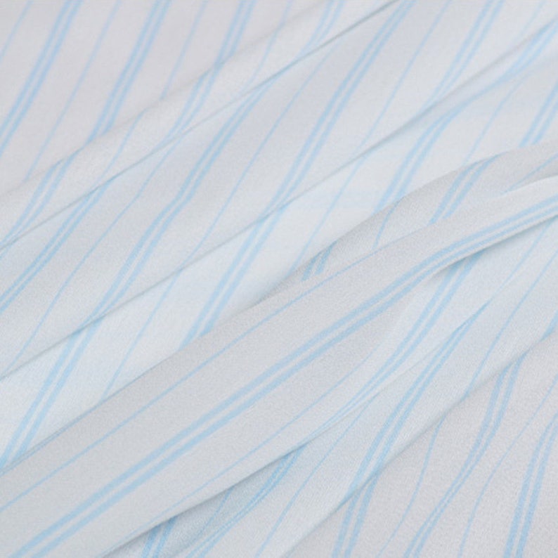 May include: White fabric with light blue diagonal stripes. The fabric has a soft, flowing texture.