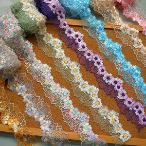 May include: Assortment of colourful floral lace trim with scalloped edges. The lace is delicate and features a variety of floral designs.