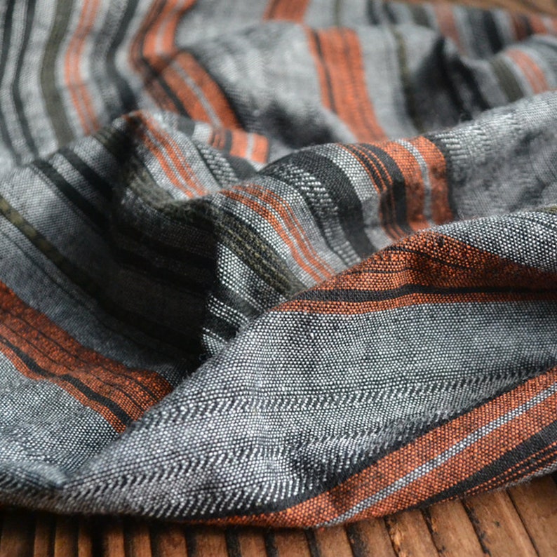 May include: Gray and orange striped fabric with a textured weave.