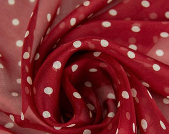 May include: Red sheer fabric with white polka dots. The fabric is folded and draped to show the pattern.