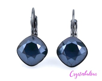 May include: A pair of silver earrings with dark blue square-shaped crystal stones.