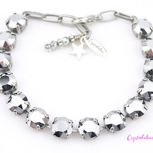 May include: A silver bracelet with a chain link clasp and a star charm. The bracelet is decorated with a row of large, faceted, black crystals.