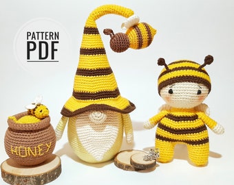 May include: Crochet bee gnome pattern PDF. The pattern includes instructions for making a bee gnome, a bee, and a honey pot. The bee gnome is wearing a yellow and brown striped hat. The bee is yellow and brown with black stripes. The honey pot is brown with the word "Honey" written on it.