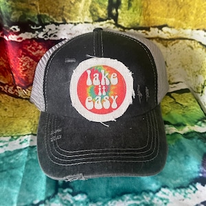 May include: Black and gray trucker hat with a white patch that says "Take it easy" in a rainbow tie-dye design.