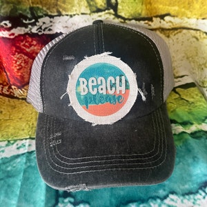 May include: A black and gray distressed trucker hat with a white, blue, and orange circular patch that says "Beach Vibes".