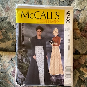 May include: McCall's Costumes sewing pattern for a long dress and jacket. The pattern is for sizes 14-16-18-20-22. The pattern is shown on two models, one wearing a black jacket and a white and floral print dress, and the other wearing a brown and floral print dress. The pattern is labeled with the text "McCall's Costumes" and "M7493".
