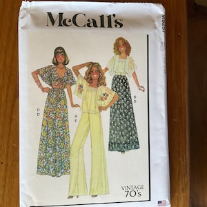 May include: Vintage McCall's sewing pattern for a 70's style outfit. The pattern includes a long skirt with a floral print, a pair of wide-legged pants, and a blouse with a lace trim.