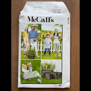 May include: A McCall's sewing pattern envelope featuring images of people gardening. The envelope has the McCall's logo and the pattern number M8300. The images show people in gardening attire with plants and gardening tools.