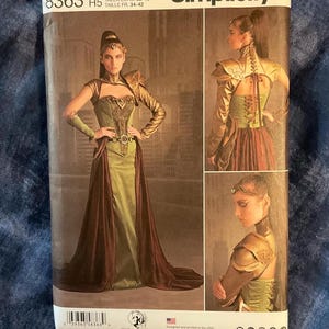 May include: Simplicity sewing pattern number 8363, size US 6-14, Euro 32-40, French 34-42, for a costume with a green and brown corset, gold accents, and a long burgundy skirt.