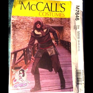 May include: A sewing pattern for a costume, featuring a person wearing a dark brown hooded tunic with a black belt and pants. The pattern is from McCall's Costumes and is size MWW (38-40-42-44).