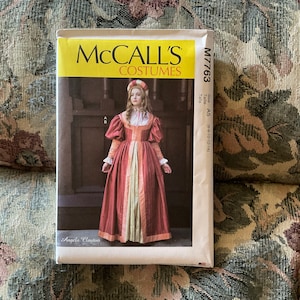 May include: McCall's Costumes sewing pattern for a Renaissance-style dress. The pattern is for sizes 6-10-12-14. The pattern features a model wearing a red and white dress with a gold trim. The pattern is labeled "M7763".