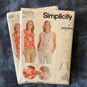 May include: Two Simplicity S9579 sewing pattern envelopes for adaptive tops. The white paper envelopes feature illustrations of models wearing floral tops with hook and loop closures, technical line drawings of four top variations, and the text Adaptive.