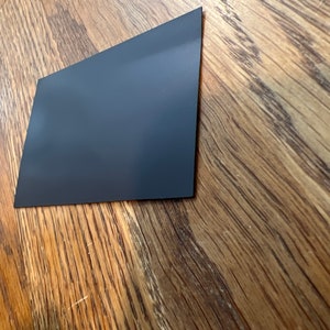 K&ouml;nnte beinhalten: Ein schwarzes rechteckiges Blatt aus magnetischem Material.