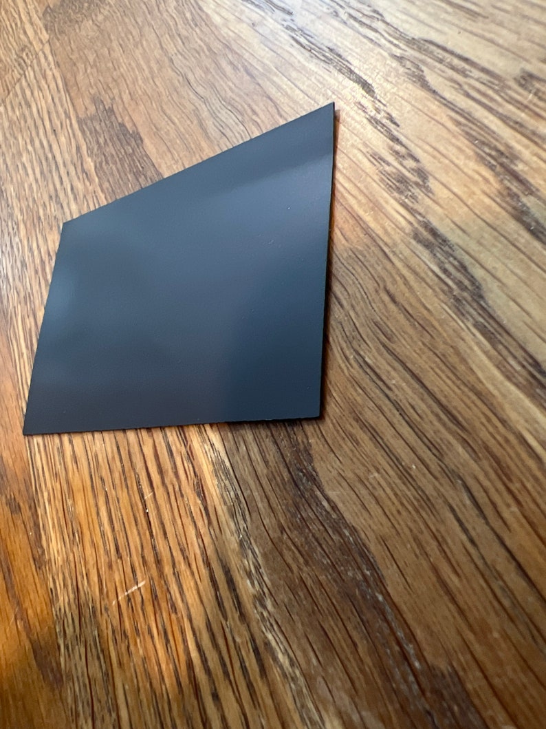 K&ouml;nnte beinhalten: Ein schwarzes rechteckiges Blatt aus magnetischem Material.