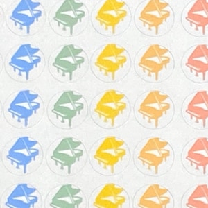 May include: A sheet of colorful stickers featuring a piano design in various colors, including pink, blue, green, and yellow. Each sticker is circular and has a white background.