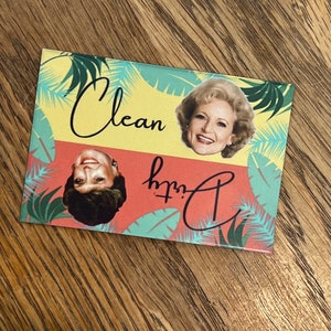 K&ouml;nnte beinhalten: Ein gelber und roter Magnet mit einem tropischen Blattdesign. Der Magnet zeigt ein Bild von zwei Frauen mit dem Text "Clean with C" in Schwarz.