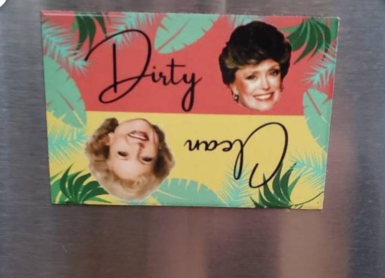 K&ouml;nnte beinhalten: Ein rosa und gelber K&uuml;hlschrankmagnet mit einem tropischen Blattdesign. Der Magnet zeigt zwei Bilder einer Frau mit blonden Haaren und den Text "Dirty Joan".