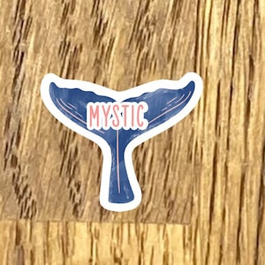 May include: A blue whale tail sticker with the word "MYSTIC" in pink lettering.
