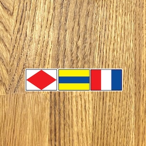 May include: Three nautical signal flags, a red diamond, a yellow and blue horizontal stripe, and a red, white, and blue vertical stripe.
