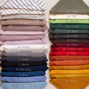May include: A collection of folded linen napkins in various colors, including sage, red, and blue. Each napkin is labeled with a number and color name, such as "Striped2" and "Dijon". The napkins are neatly stacked, showcasing a range of hues.