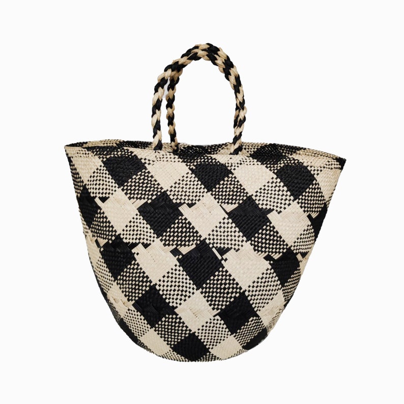 Puede incluir: Un bolso tote grande de cuadros negros y blancos con asas tejidas. El bolso est&aacute; hecho de un material natural y tiene un fondo redondeado.
