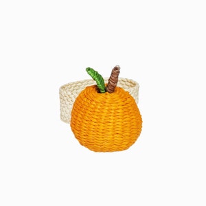 Op de afbeelding: Oranje gevlochten servetring met een groene steel en een bruin midden. De ring is gemaakt van natuurlijke materialen en heeft een lichtbruine basis.