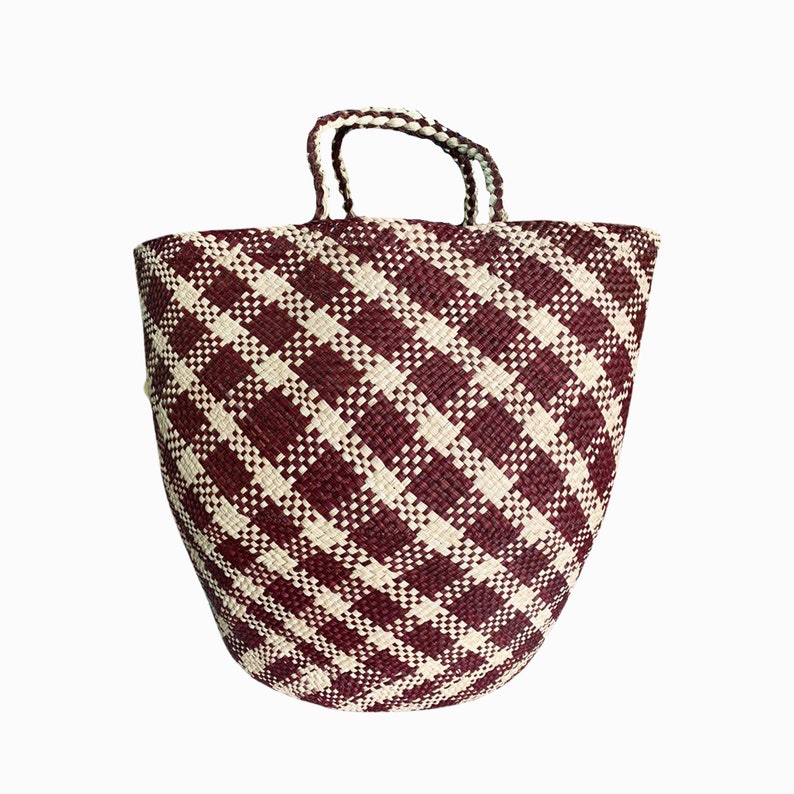 Puede incluir: Un bolso tote grande tejido con un patr&oacute;n de cuadros burdeos y blanco. El bolso tiene dos asas y est&aacute; hecho de fibras naturales.