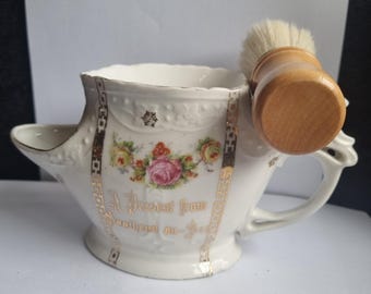 Antigua taza de afeitar de porcelana de principios del siglo XX con decoración de transferencia. Un regalo de Southend en una taza de afeitar de porcelana con cepillo nuevo.