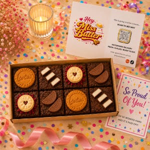 May include: A rectangular cardboard box containing eight square chocolate brownies topped with various biscuits and chocolate pieces. The box is accompanied by a white card with the text Hey Miss Butter and a QR code, and a card reading So Proud of You.