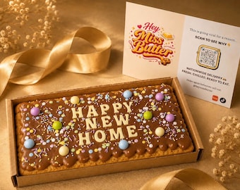 May include: A rectangular cake with chocolate frosting and the words "HAPPY NEW HOME" in white icing. The cake is decorated with colorful sprinkles and pastel-colored candies. A card with the text "Hey Miss Butter" is next to the cake.