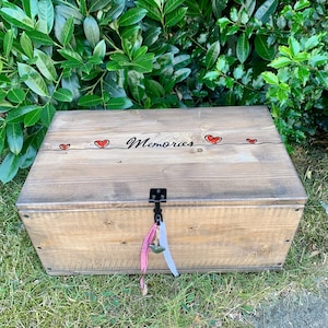 Peut inclure: Une boîte en bois avec un couvercle à charnières et un loquet en métal. La boîte est peinte en brun et porte l'inscription « Memories » en lettres cursives noires sur le dessus. Trois cœurs rouges sont peints sur le dessus de la boîte.