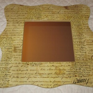 Miroir en bois (de médium) recouvert de papier de qualité de la marque Toga. Motif écriture.