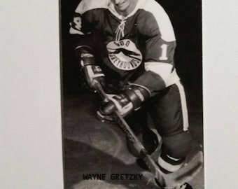 May include: Black and white photograph of a hockey player in uniform, holding a hockey stick. The player is wearing a jersey with the number 1 and the text "Greyhounds". The name "WAYNE GRETZKY" is printed at the bottom.