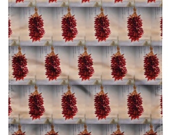 Puede incluir: Un patrón repetido de ristras de chiles rojos, cada una atada con una fibra natural. El fondo tiene una combinación de colores neutros con líneas verticales. Las ristras son de color rojo intenso.