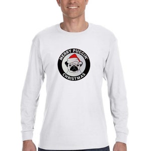 May include: White long-sleeve t-shirt with a black circle graphic featuring a pug wearing a Santa hat. The text "Merry Puggin' Christmas" is written around the circle.