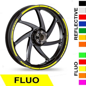 May include: A black motorcycle wheel rim with a yellow reflective stripe. The stripe is on the outer edge of the rim and has a dashed pattern. The image shows the wheel rim against a white background. The words "FLUO" and "REFLECTIVE" are shown in a column on the right side of the image.