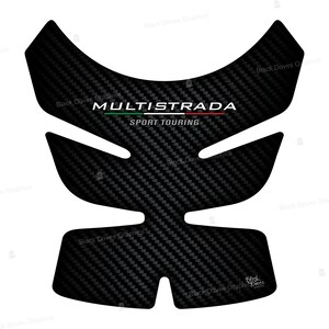 Peut inclure: Protection de r&eacute;servoir de moto en fibre de carbone noire avec le texte "MULTISTRADA SPORT TOURING" en blanc. Le design pr&eacute;sente un motif textur&eacute; et une barre de couleur avec des rayures vertes et rouges. La forme est con&ccedil;ue pour s'adapter &agrave; un r&eacute;servoir de moto.